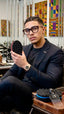 Man holding a shoe sole inspection mirror in a barbershop setting