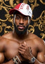 Man wearing a red and white cap with 'STYLE' text, posing against an ornate gold and black background.