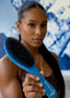 Woman holding a blue hairbrush with a blurred natural background