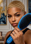 A woman with a short blonde braided hairstyle holds a blue hairbrush with black bristles in front of her face. The brush has the brand name 'SPI-STY' printed in white near the handle.