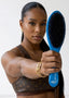 Woman holding a blue hairbrush with a white background