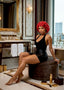 Woman in a black dress with a red headscarf in an elegant bathroom.