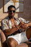 Man wearing sunglasses and a patterned shirt sitting on a couch.