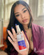Woman holding a bottle of hair product with a blurred background