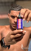 Man holding a bottle of hair product with a blurred background
