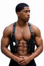 A muscular man wearing a black tactical chest holster system with two handguns, photographed against a solid white background.