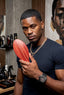 Man holding a red comb in a barbershop setting