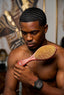 Man holding a hairbrush in a room with decorative elements