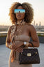 Woman holding a Louis Vuitton handbag with a cityscape background