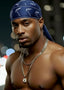 Man wearing a blue headscarf and chains with a blurred background
