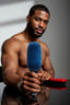 Man holding a blue hairbrush with a red brush in the background