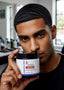 Man holding a jar of SilStyles luxurious hair product in a kitchen setting