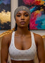 Woman wearing a patterned sports bra in a room with colorful abstract art on the wall.
